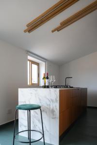una encimera de mármol blanco en una cocina con taburete en Vetriera41, en Castelbuono