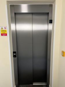 een zilveren liftdeur in een gebouw met een bord bij Borough Central London in Londen