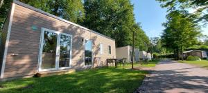 a house with a yard next to a building at Chalet type F in Voorthuizen
