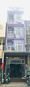 a purple building with a motorcycle parked in front of it at Huế thương Hotel in Hue