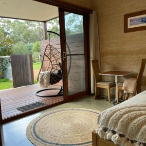 a bedroom with a door open to a deck at Grape Juice Retreat in Margaret River Town