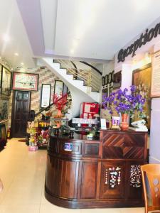 a restaurant with a counter with flowers on it at Huế thương Hotel in Hue