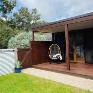 una casa con una silla de mimbre sentada en una cubierta en Grape Juice Retreat en Margaret River