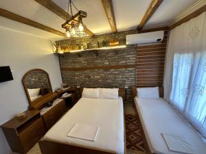 mały pokój z 2 łóżkami i lustrem w obiekcie Ahmetaj Guest House w Gjirokastrze