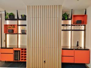 a kitchen with orange and brown cabinets and shelves at Luxury suite con vista increíble Quito Carolina Coliving Ecuador in Quito