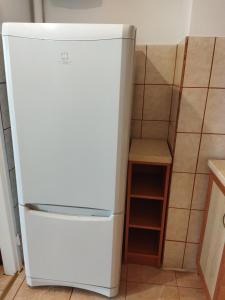 a white refrigerator in a kitchen next to a stool at Apartament/mieszkanie-Wałbrzych Piaskowa Góra in Wałbrzych