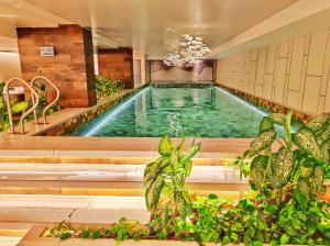 a pool in a building with plants in the foreground at Luxury suite con vista increíble Quito Carolina Coliving Ecuador in Quito