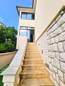 a staircase leading up to a house with a stone wall at APARTMAN MARKO 2 in Novi Vinodolski