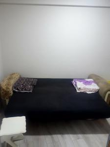 Una cama negra con dos almohadas encima. en I can host, en Bursa