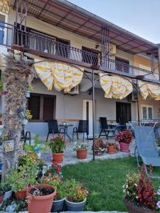 une terrasse d'un hôtel avec des chaises et des fleurs dans l'établissement Rooms Marijeta, à Skradin