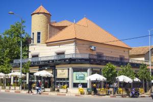 un edificio con mesas y sombrillas delante en Hôtel La Chambotte, en Imouzzer Kandar