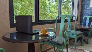 a table and chairs with a laptop on it at Hôtel La Chambotte in Imouzzer du Kandar