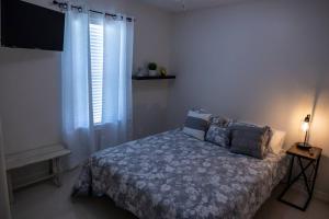 a bedroom with a bed and a television and a window at Cozy home with POOL and free WIFI in Brownsville