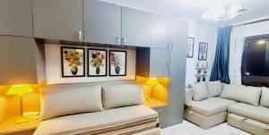 sala de estar con paredes amarillas y sofá blanco en استيديو علوى بورتو سعيد porto said Studio in a resort, en `Ezbet Shalabi el-Rûdi
