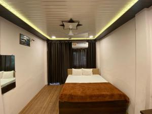 a small room with a bed and a ceiling at Hotel khatu shyam palace in Ujjain