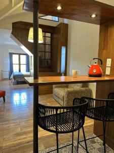 a kitchen with a counter with chairs and a red kettle at TOWER Adults only in Villa General Belgrano