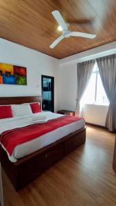a bedroom with a large bed with a ceiling fan at Skylight Apartment in Nuwara Eliya