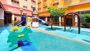 um parque infantil num hotel com escorrega em Neat Unit in Holland Park Southwoods em Biñan