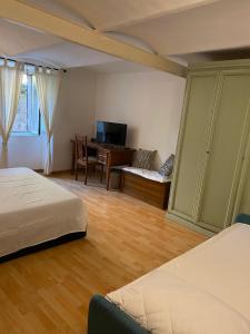 a bedroom with two beds and a desk with a computer at Da Nonna Puni in Orvieto +3 photos