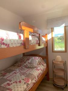 a bedroom with two bunk beds and a window at Cabaña Familiar de Descanso y Paseo - Puyehue in Puyehue