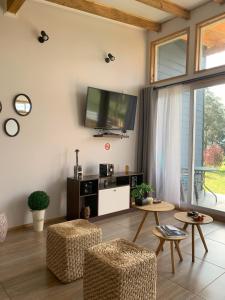 ein Wohnzimmer mit einem TV, einem Tisch und Stühlen in der Unterkunft Cabaña Familiar de Descanso y Paseo - Puyehue in Puyehue