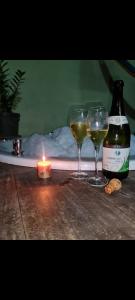 two glasses of wine and a candle on a table at Morooka ÁGUA chalé com hidromassagem ALTER CHÃO in Alter do Chao