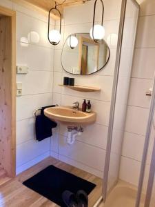 a bathroom with a sink and a mirror at Kastnhäusl Wildschönau - urige Hütte mit Bergblick in Oberau