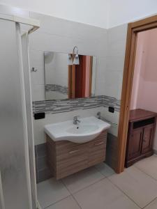 een badkamer met een wastafel en een spiegel bij Tranquillo ed economico in Calvizzano