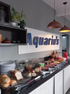 a buffet line with various types of bread and pastries at Aquariu's Pousada e Restaurante in Cêrro Negro