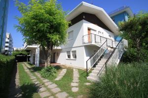 a white house with stairs and a tree at Villa Ca'Bianca in Bibione