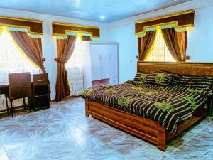 a bedroom with a bed and a desk and windows at Select Elegant 3 Rooms 3 sized king-bed @ Abuja FCT in Abuja