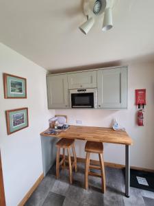 cocina con mesa de madera y microondas en Hillview, en Inverness