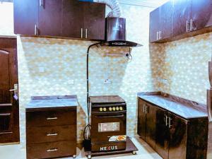 a kitchen with a stove and a counter top at Select Elegant 3 Rooms 3 sized king-bed @ Abuja FCT in Abuja