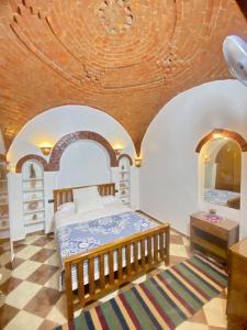 - une chambre avec un lit et un plafond en bois dans l'établissement Shahhat House, à Louxor