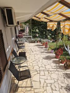 une terrasse avec des chaises, une table et un parasol dans l'établissement Rooms Marijeta, à Skradin