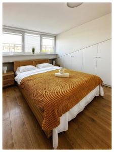 ein Schlafzimmer mit einem großen Bett und Holzboden in der Unterkunft Apartaments in the city centre in Kaunas