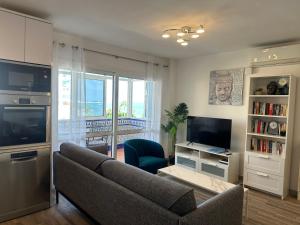 a living room with a couch and a television at Luxury beachfront apartment in Benalmadena Costa in Benalmádena