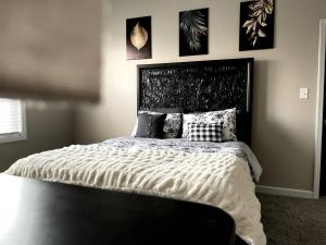 a bedroom with a large bed with a black headboard at Beautiful home with Viking Royale Spa conveniently located near the Marines in Jacksonville