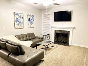 a living room with a couch and a fireplace at Beautiful home with Viking Royale Spa conveniently located near the Marines in Jacksonville
