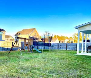 a playground with two swings in a yard at Beautiful home with Viking Royale Spa conveniently located near the Marines in Jacksonville
