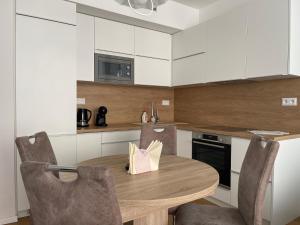 a small kitchen with a wooden table and chairs at SAG Sky Park Residence Free parking and Wi-Fi in Bratislava