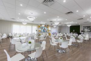 un salón de banquetes con mesas blancas y sillas blancas en Magic Moment Resort and Kids Club, en Kissimmee