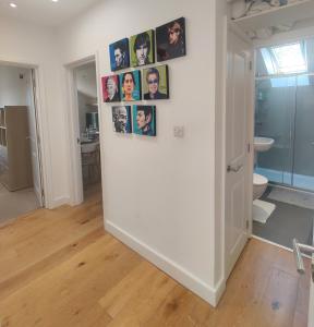 einen Flur mit einer Wand mit Bildern darauf in der Unterkunft Light modern 1 bedroom apartment in Cambridge
