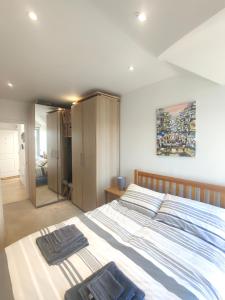 a bedroom with a large bed and a mirror at Light modern 1 bedroom apartment in Cambridge