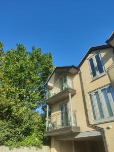 an apartment building with a balcony and a tree at Light modern 1 bedroom apartment in Cambridge