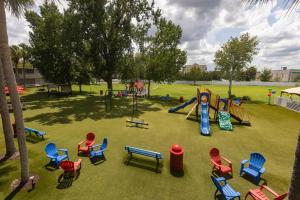 a park with a playground with chairs and a slide at Magic Moment Resort and Kids Club in Kissimmee