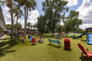 a playground with chairs and a slide in a park at Magic Moment Resort and Kids Club in Kissimmee