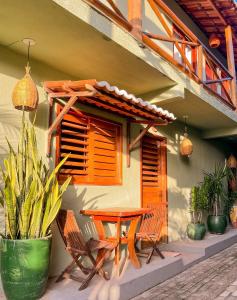 a table and chairs sitting outside of a house at Kadosh Pipa Hospedagem in Pipa