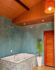 uma casa de banho com uma banheira e um vaso de plantas em Kadoshi Pipa Boutique Hospedagem em Pipa