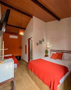 a hotel room with two beds and a tv at Kadosh Pipa Hospedagem in Pipa